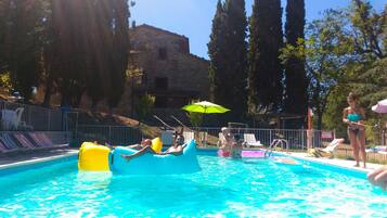 Relax by the pool with lounge chairs and umbrellas offering shade.