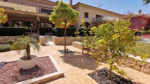 A courtyard with potted plants, a palm tree, and a stone wall. - Exclusive apartment, big terrasse 4 pools, close to restaurants beaches and golf (Benissa)