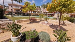 A resort with a pool, palm trees, and a stone wall. - Exclusive apartment, big terrasse 4 pools, close to restaurants beaches and golf (Benissa)
