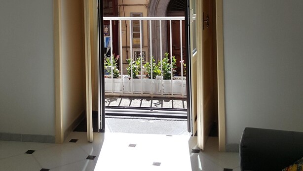 An open doorway leading to a balcony with a view of a building with a yellow facade and a white railing. - Apartment in the heart of Sorrento, 10 meters from Piazza Tasso (Sorrento)
