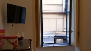 A room with a bed, a TV on the wall, a window, and a dresser. - Apartment in the heart of Sorrento, 10 meters from Piazza Tasso (Sorrento)