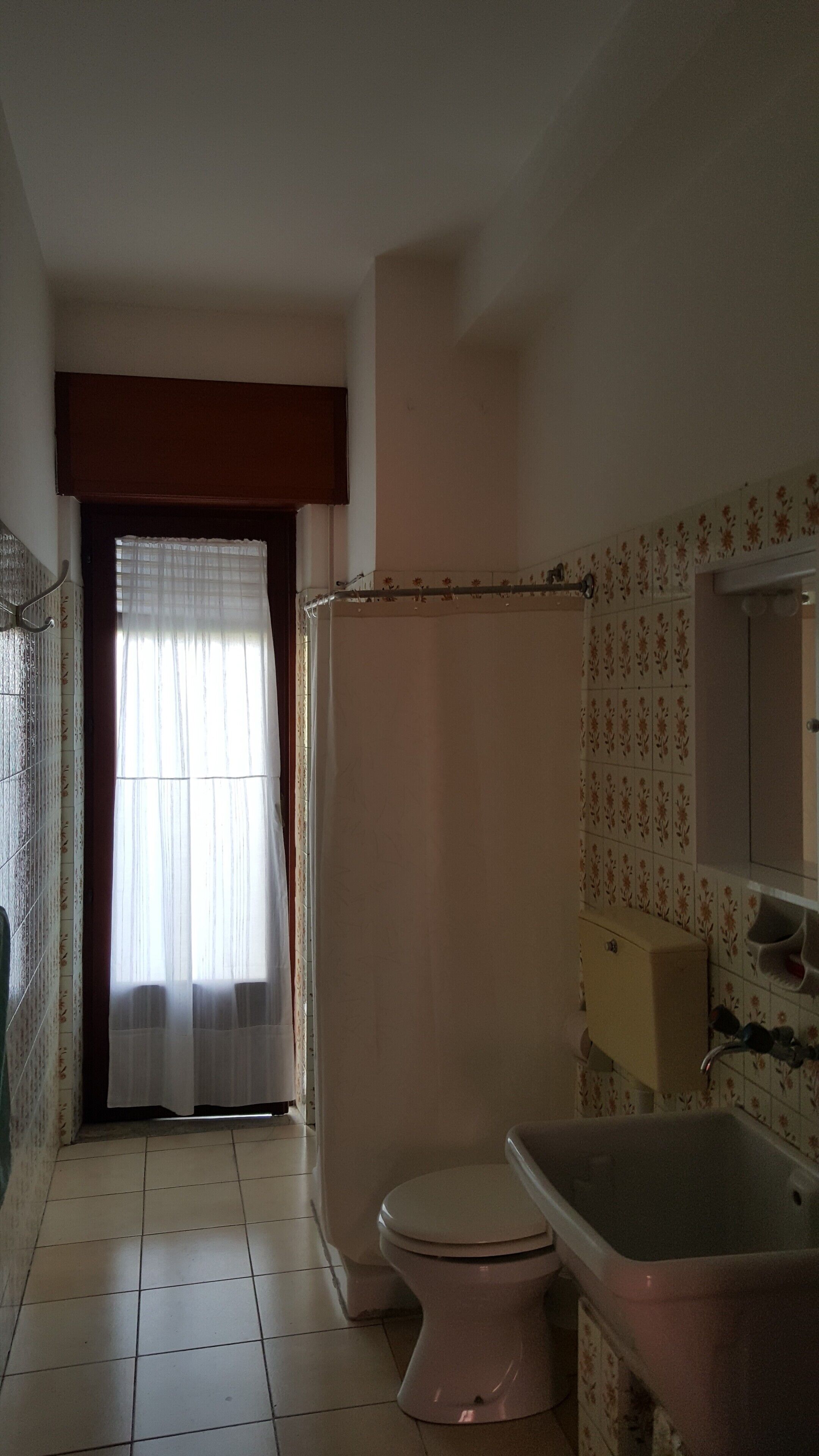 A bathroom with a toilet, a bathtub, and a shower area.