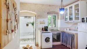 A compact kitchen with a washing machine, a microwave, and a small oven.
