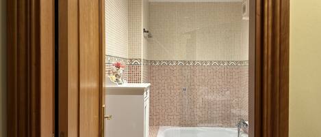 A bathroom with a bathtub, toilet, and sink.
