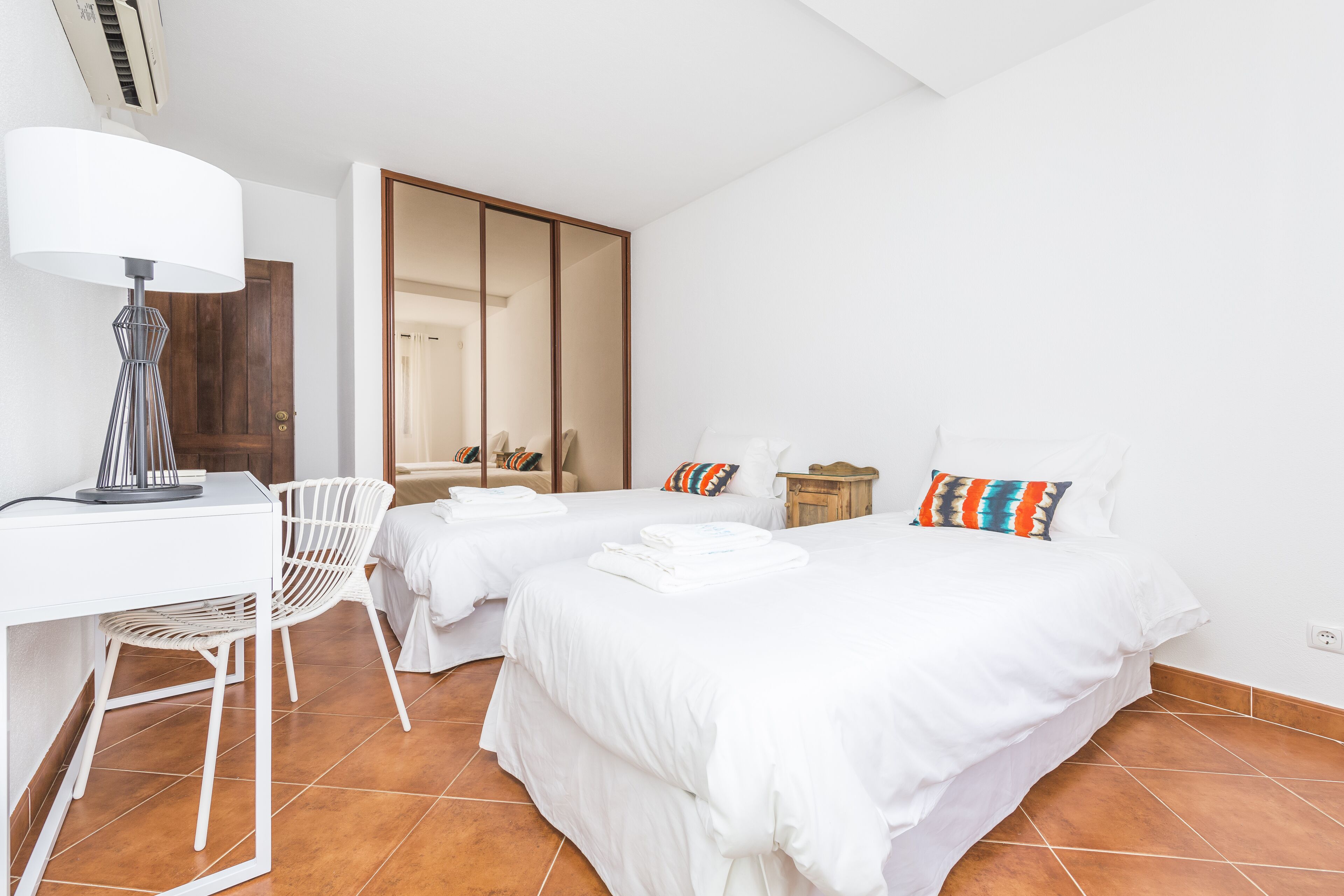 Une chambre d’hôtel avec deux lits, un bureau et une chaise.