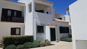 A white building with balconies and a tiled roof. - CASAS DA PRAIA,   55 (Almancil)