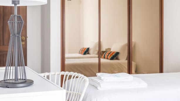 A neatly made bed with white linens, a modern lamp, and a wooden wardrobe in the background. - CASAS DA PRAIA,   55 (Almancil)