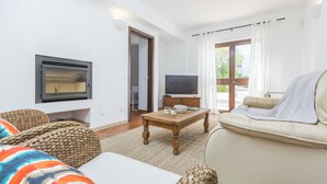 A living room with a sofa, a coffee table, a television, and a fireplace. - CASAS DA PRAIA,   55 (Almancil)
