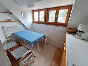 A small kitchenette with a table, chair, and a coffee maker. - Beautiful apartment in a huge house in the Vosges (Hohrod)