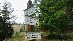 A directional signpost with multiple arrows pointing towards various destinations. - Beautiful apartment in a huge house in the Vosges (Hohrod)