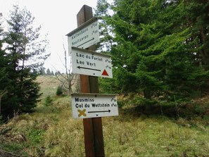 A directional signpost with multiple arrows pointing towards various destinations. - Beautiful apartment in a huge house in the Vosges (Hohrod)