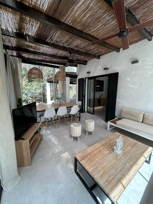 A modern living room with a wooden coffee table, white sofas, and a TV.