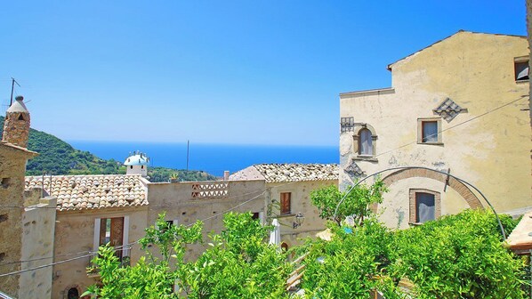 A coastal town with traditional architecture, including a building with a dome and tiled roofs. - Ecotourism in the Medieval Village of Calabria, tradition and culture, sea and nature... (Belmonte Calabro, Cosenza)