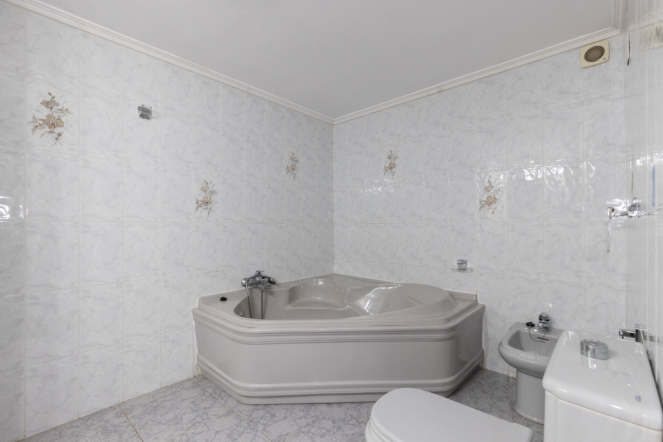 Ein Badezimmer mit einer großen Badewanne, einer Toilette und einem Bidet.