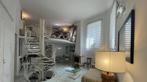 Un vaste espace de vie comprenant un escalier en colimaçon, une table à manger et un canapé.