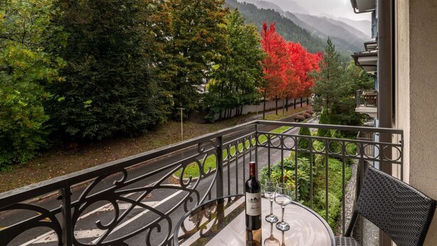 A balcony with a view of a river, trees, and mountains. - Apartment Staddon - Alpes Agency - Central Chamonix - Sleeps 6 (Chamonix-Mont-Blanc)