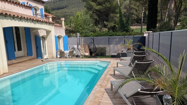 A swimming pool with lounge chairs and a patio area.