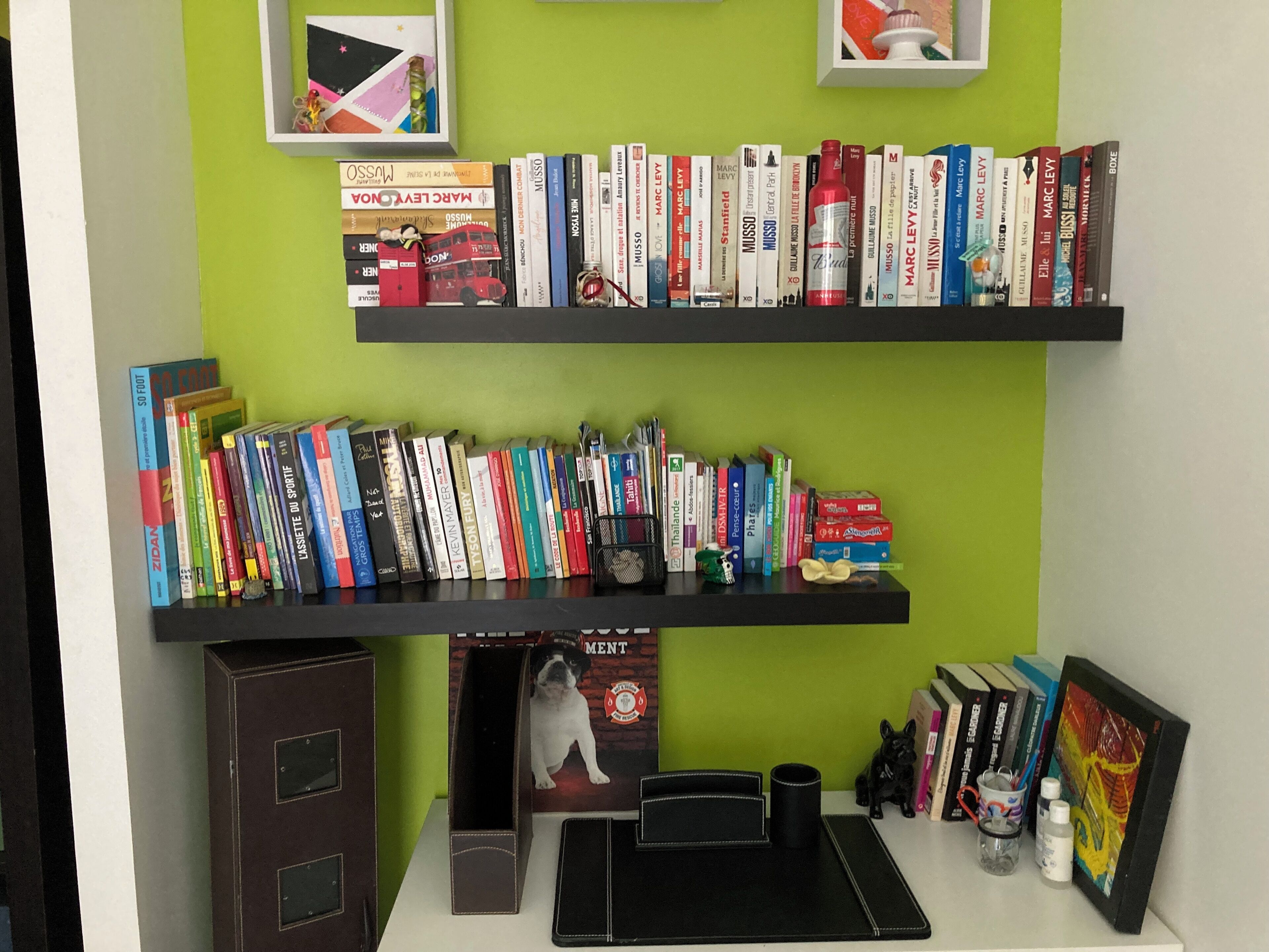 Una estantería con libros y un cuadro enmarcado.