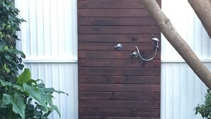 Une porte en bois, dotée d’une poignée en métal et d’une petite marche menant à un sentier pav é de pierres.