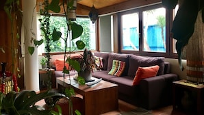 Un salon chaleureux avec un canapé, une table basse et diverses plantes.