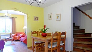 A dining area with a wooden table and chairs, a potted plant, and a staircase leading to a landing. - Vineyard cottage classified 4* with large pool between Carcassonne and Narbonne (Ferrals-Les-Corbières)