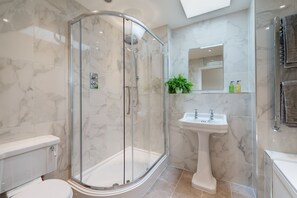 Bañera con ducha, secador de pelo, toallas, papel higiénico