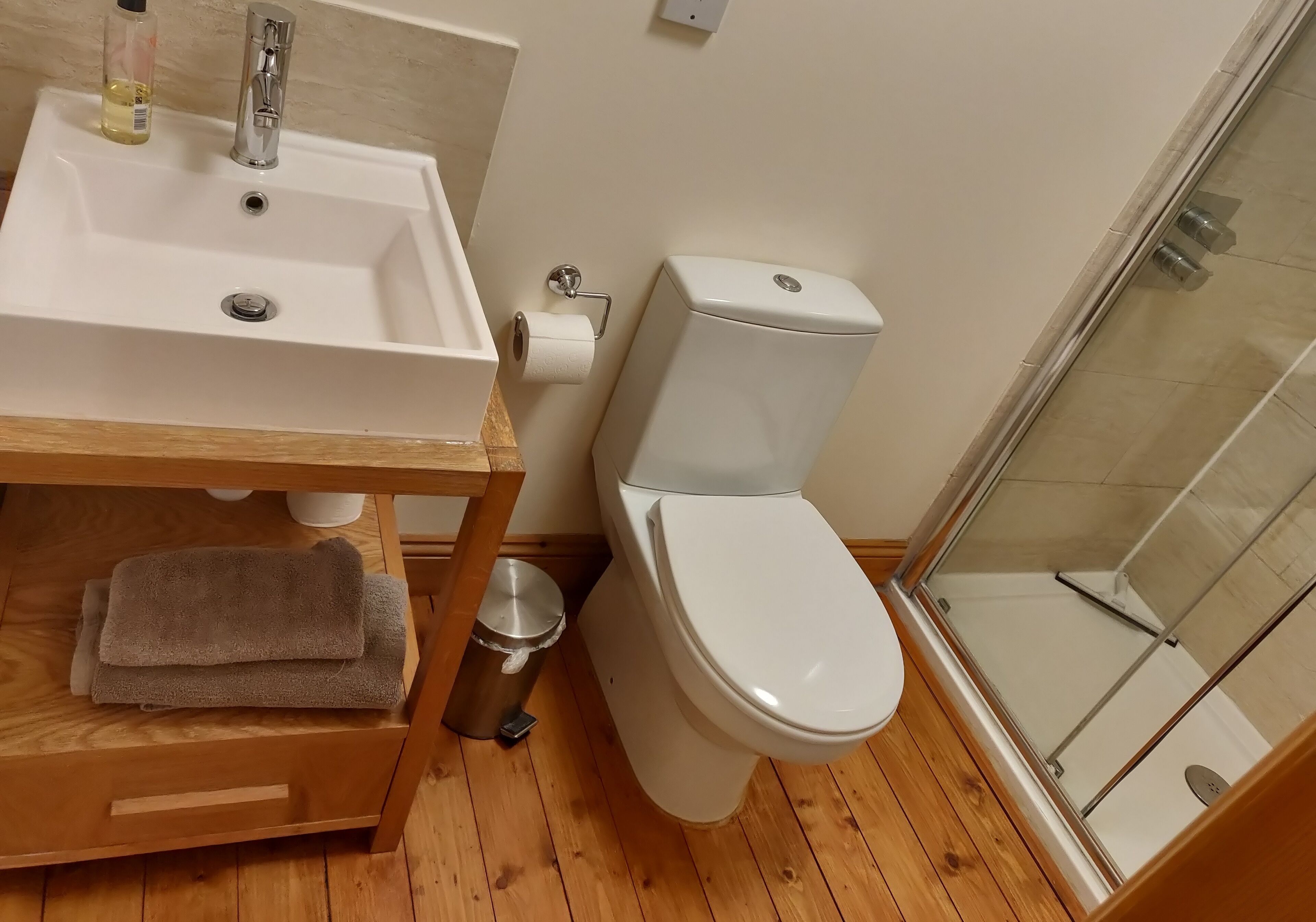 A bathroom with a sink, toilet, and shower.