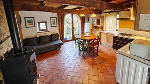 Uma cabana aconchegante com lareira, área de jantar e cozinha.