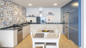 Eine moderne Küche mit Kochinsel, weißen Schränken und einer strukturierten Spritzschutzwand.