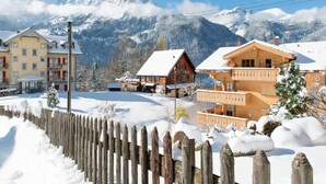 A snow-covered mountain village with traditional wooden houses, a wooden fence, and a clear view of the mountains in the background. - Panoramapark Soleil Camelia Apt. Akroyd (Wengen)
