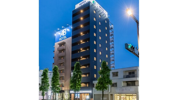 Un hôtel à plusieurs étages, sur lequel on peut voir une grande enseigne lumineuse indiquant « HÔTEL ».