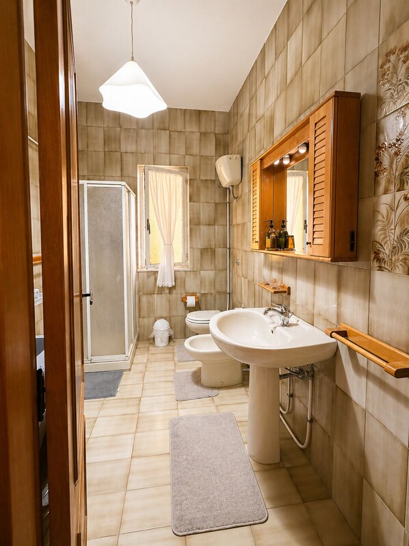 Ein modernes Badezimmer mit einem großen Waschbecken, einer Toilette und einer Duschkabine.