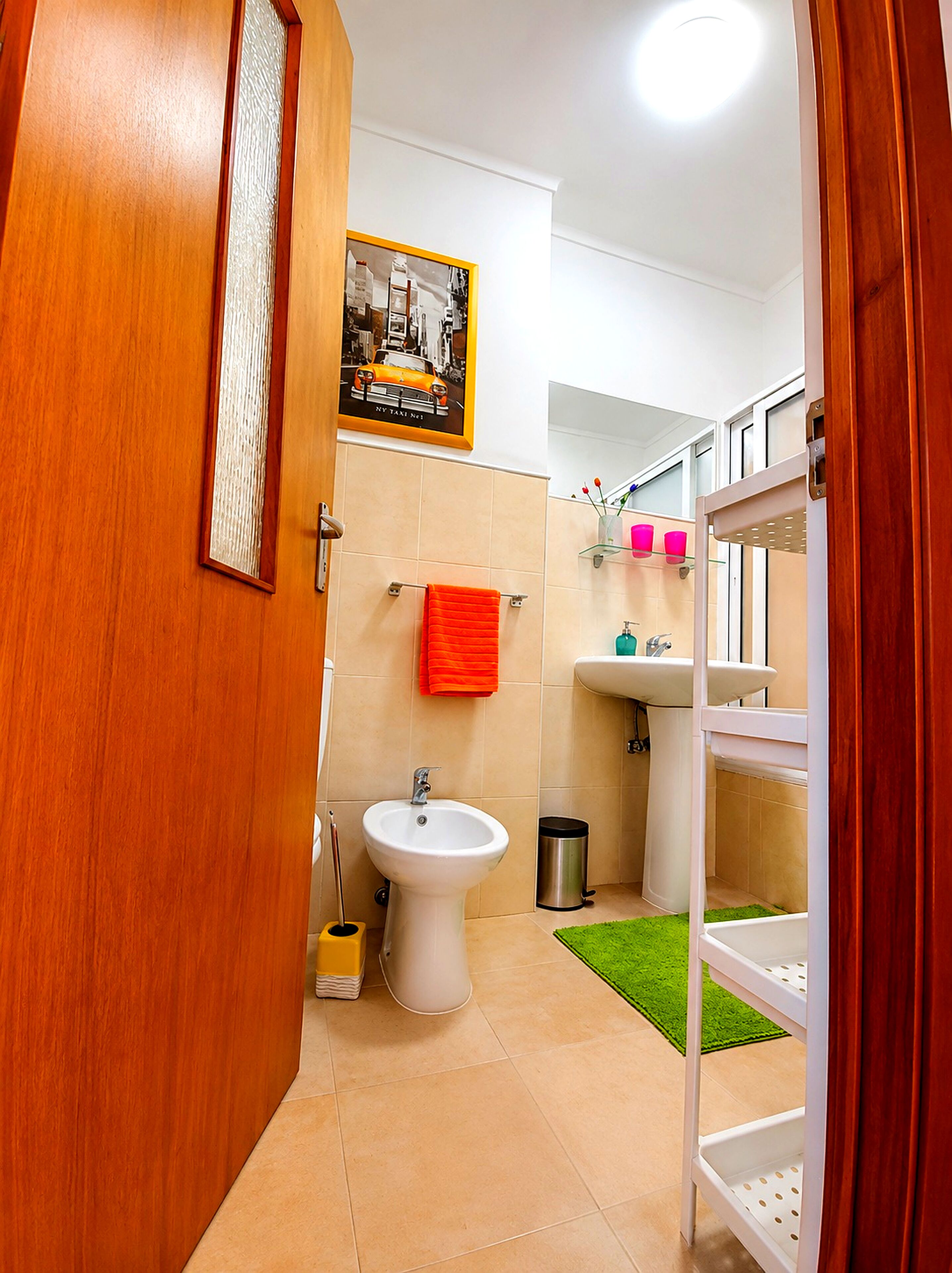 Ein Badezimmer mit einer Bidet, einem Waschbecken und einem Spiegel.