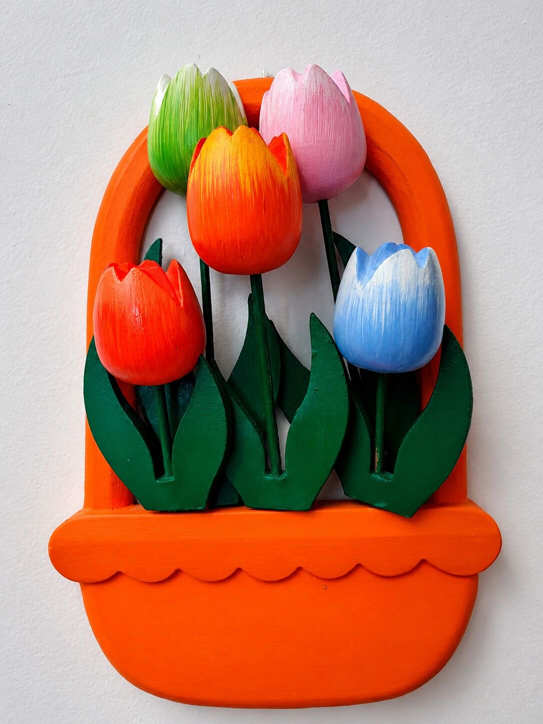 En färgstark blomsteruppsättning i en dekorativ, orange kruka.