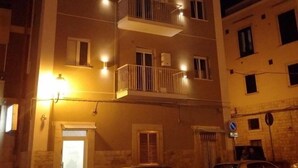 Un immeuble à plusieurs étages doté de balcons et d’un éclairage extérieur.