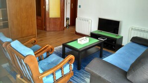A living room with a wooden cabinet, a television, and a sofa. - Residential tourist use with WiFi (Villarcayo)