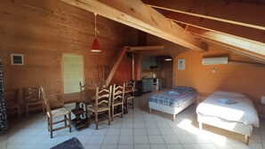 Eine Holzhütte mit Essbereich, zwei Schlafzimmern, einer Küche und einer Treppe.