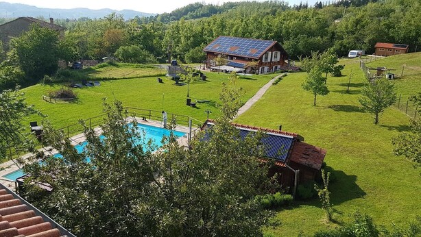 Ein Wohngebiet mit Schwimmbad, Solaranlage und einem Haus mit rotem Dach.