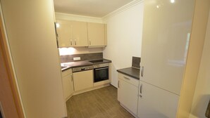 A compact kitchen with a stove, oven, and refrigerator.