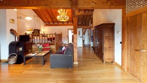 Ein geräumiges Wohnzimmer mit Kamin, Sofa und Holzboden.