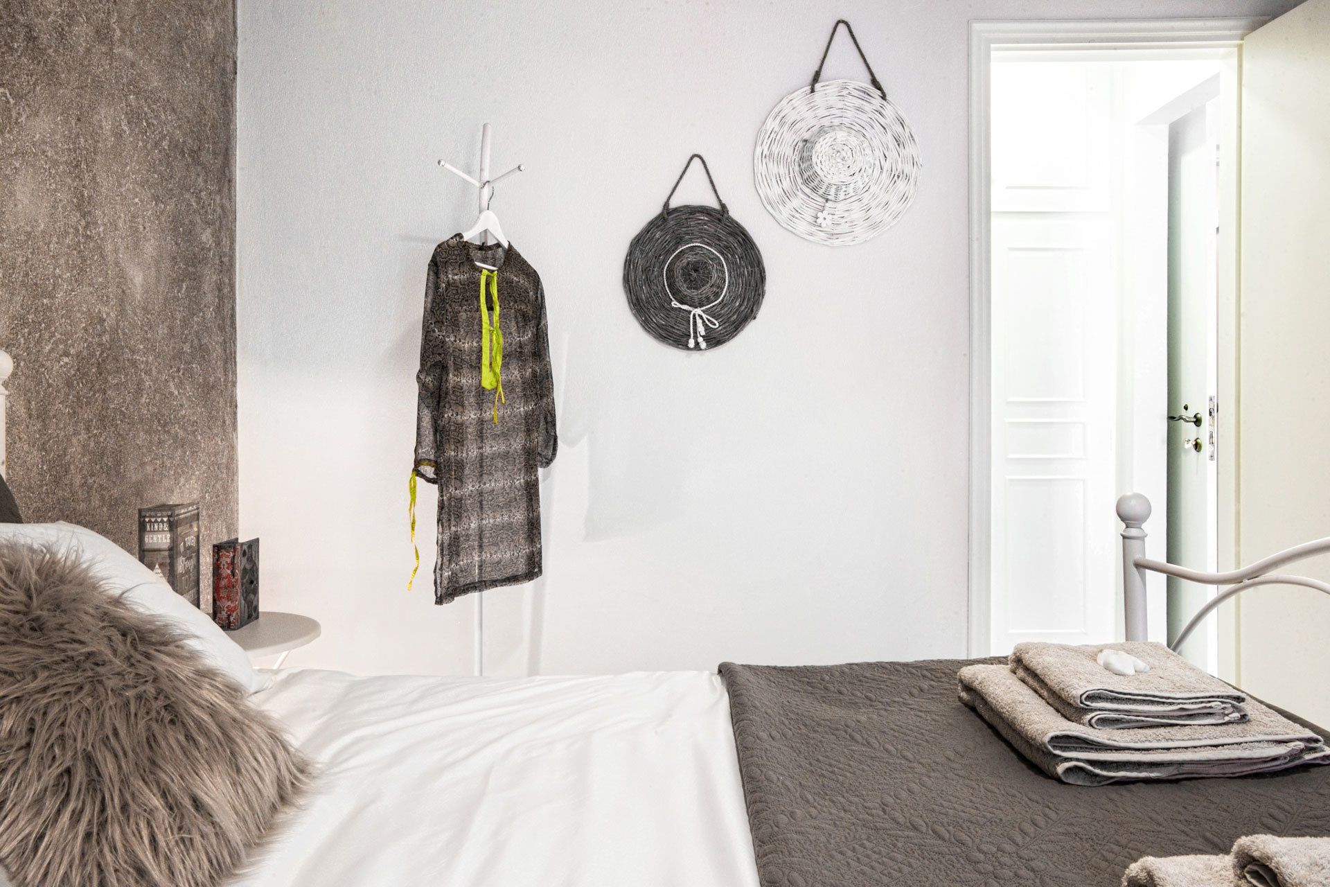 Ein Schlafzimmer mit einem Bett, einem Hängehandtuchhalter und einer Tür.