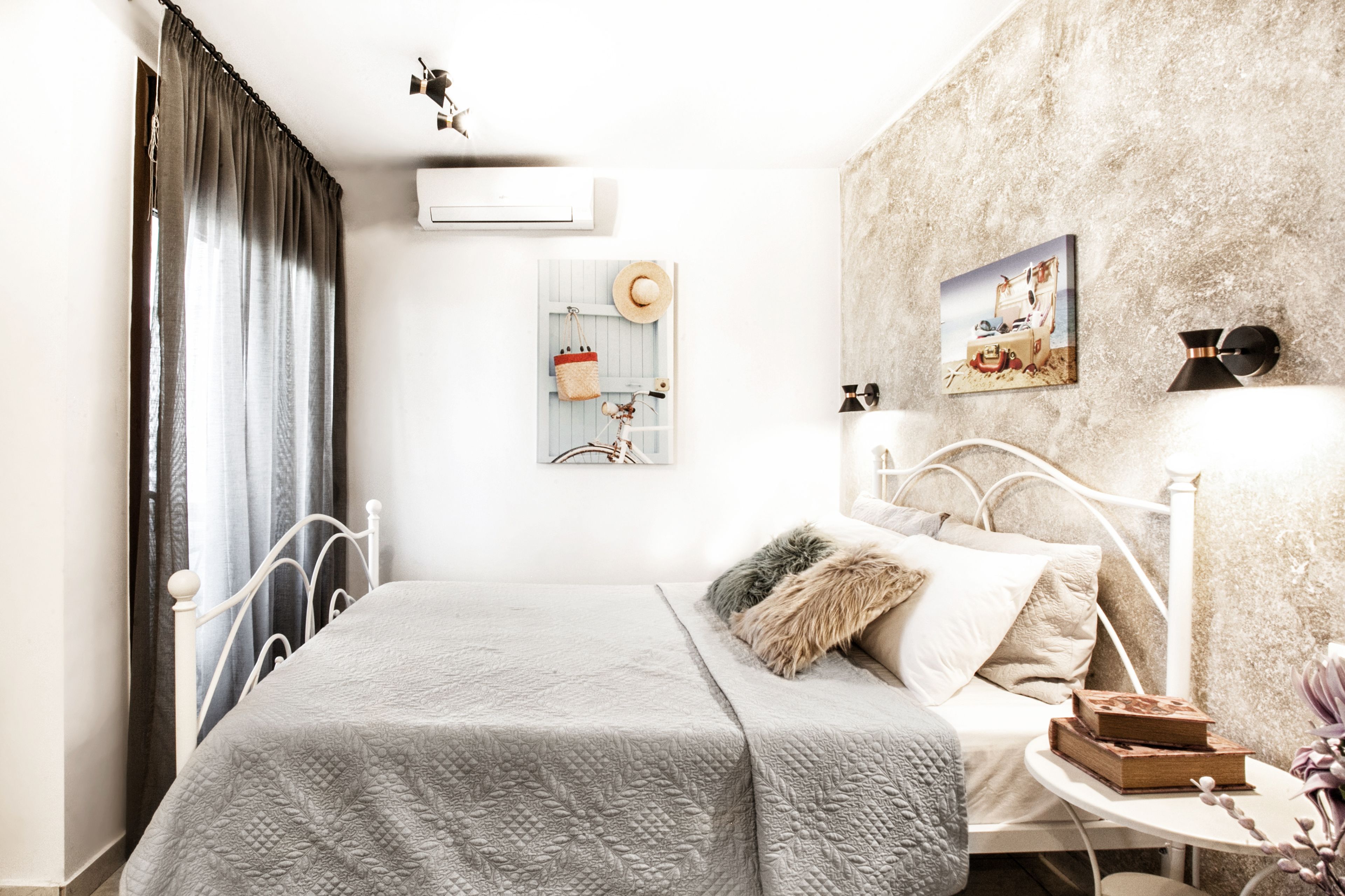 Una camera da letto con un letto, un comodino, un condizionatore d'aria a parete e una parete con texture.