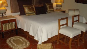 A neatly arranged bedroom with a bed, two bedside tables, a chair, and a lamp. - Beautiful country house in the magical town of Malinalco (Malinalco)