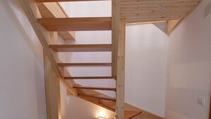 Un escalier en bois avec une lucarne donnant sur un niveau inférieur.