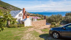 A house with a stone wall, a satellite dish, and a view of the sea. - Private pool family home with open sea view (Bol)