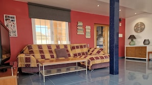 A modern living room with a sofa, a coffee table, and a TV.