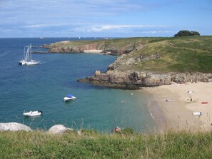 A coastal beach with boats, a sandy shore, and rocky cliffs. - Gite 37 bis rue du pré de la dame. (Férel)