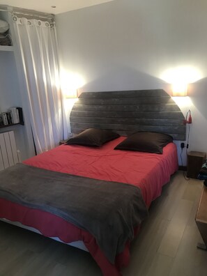 Cozy retreat with a large bed, reading lights, and a nightstand.