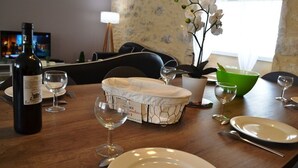A dining table set with plates, wine glasses, and a basket. - Gite 8 people - forge - Monsegur (Monségur)