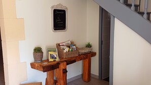 A wooden bench with wicker baskets and a small table with magazines and a plant. - Gite 8 people - forge - Monsegur (Monségur)